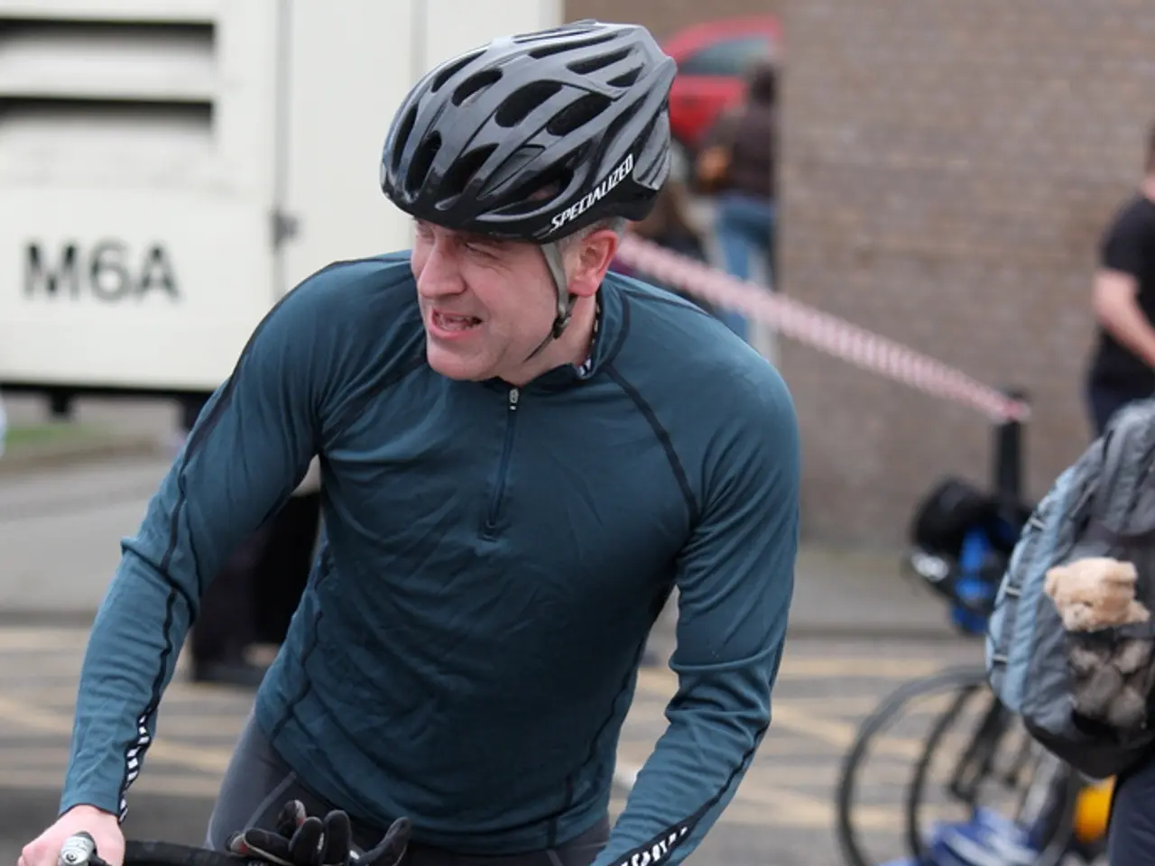 As we can see in the image there is a man wearing helmet and holding bicycle.