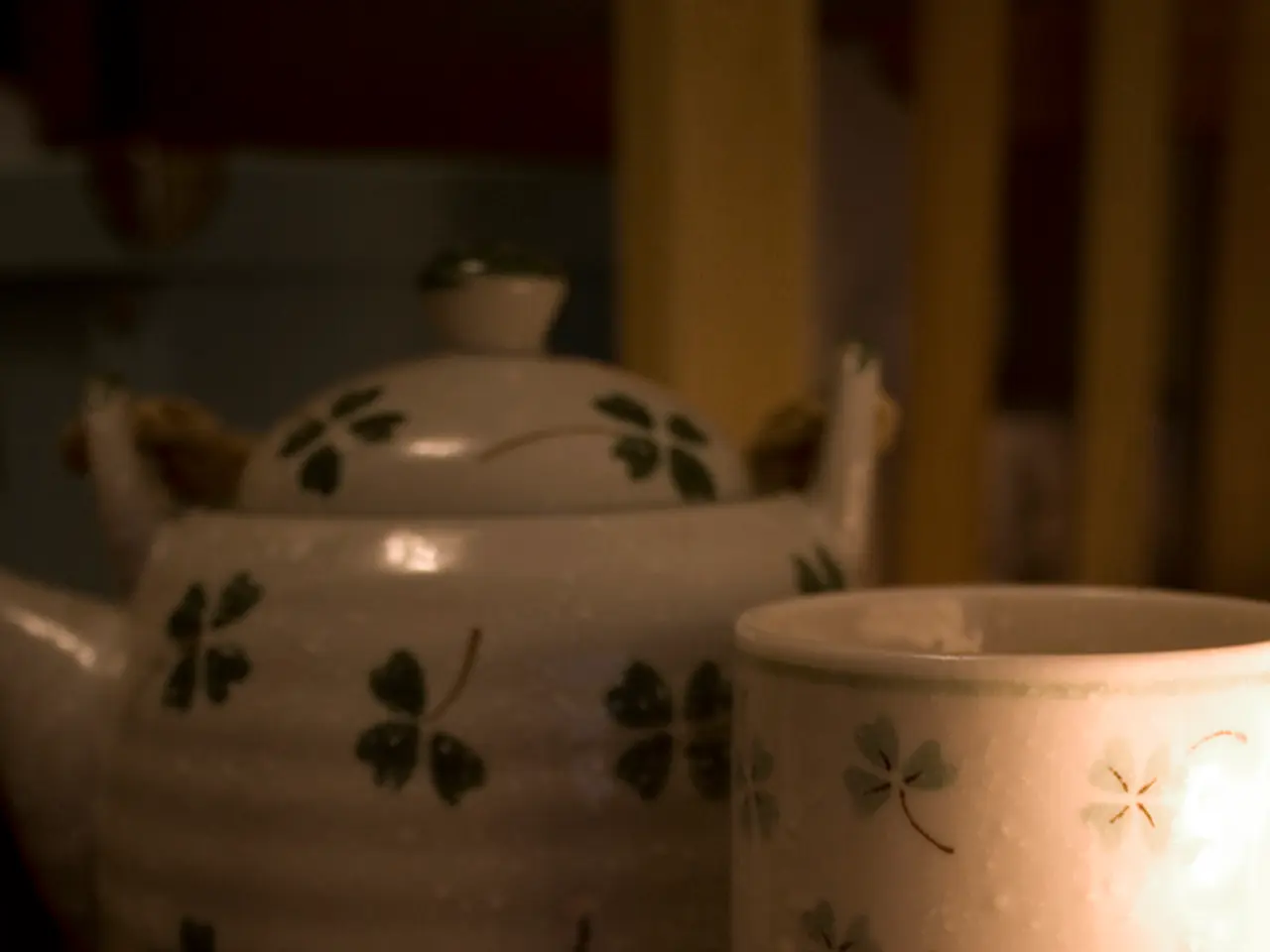 In this image, we can see a kettle, cup and comb.