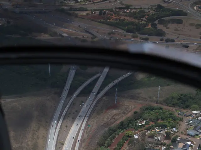 This image is taken from inside the airplane. In this image we can see there is a glass of an...