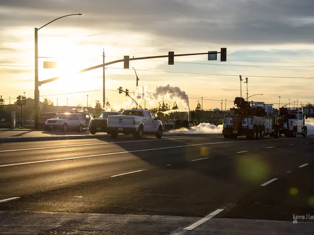 In this image we can see some vehicles which are moving on the road there are some traffic signals...