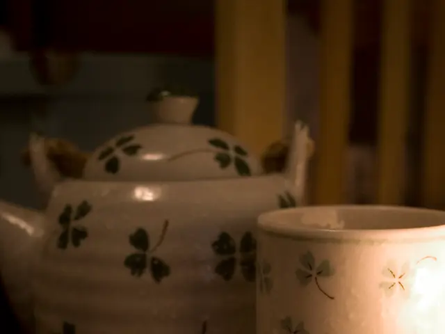 In this image, we can see a kettle, cup and comb.