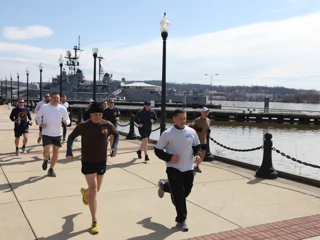 In this image there are so many people running on the bridge, beside them there are some street...